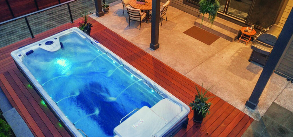 outdoor swim spas - swim spa at night with water fountains