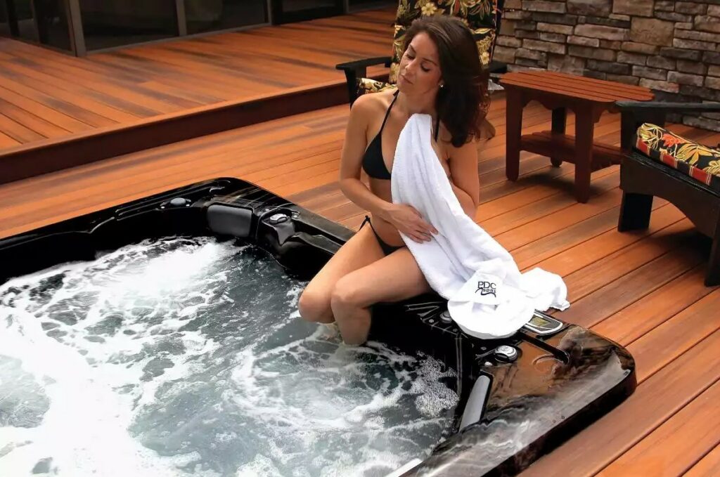 woman sitting by a hot tub on a deck