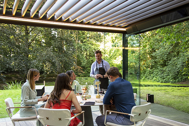 friends under a renson pergola outfitted with smart technology for shades and screens